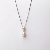 Conjunto de collar y aros en plata 925 con perlas de río y circonias. El collar tiene una cadena de 42cm y dos perlas colgantes de 6,5mm y 8,5mm.