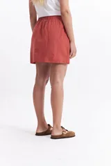 Minifalda negra de algodón con cintura elastizada con lazo regulable y bolsillos laterales.