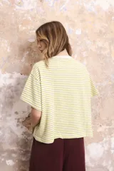 Remera de algodón a rayas horizontales color verde claro y blanco, con cuello redondo y mangas cortas.