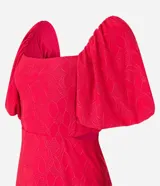 Vestido corto evasê rojo con bordado floral, escote cuadrado, mangas cortas abullonadas y espalda descubierta.