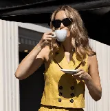 Chaleco color crema de lino con cuello solapa y doble botonadura con botones marrones.