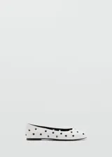 Zapato tipo ballerina color blanco con perforaciones circulares y punta redonda.