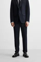 Pantalón de vestir azul marino, de corte slim fit, con bolsillos laterales y traseros de vivo con botón. Se ajusta a la cintura con cierre frontal con cremallera y botón.