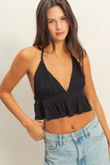 Top negro con textura de lunares, escote halter y peplum.
