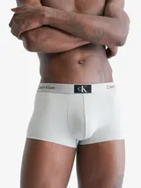 Pack de tres bóxers Calvin Klein de corte low rise trunk, con cinturilla elástica con logo de la marca. Incluye un bóxer negro, uno gris y uno naranja.