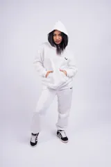 Conjunto deportivo blanco compuesto por un hoodie con capucha y un pantalón de jogging. Ambos tienen un logo pequeño en color negro.
