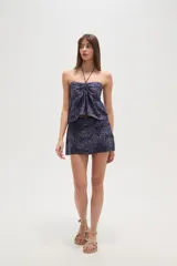 Top sin mangas con estampado de azulejos en tonos blanco y azul, con cuello halter y detalle fruncido en el centro del busto.