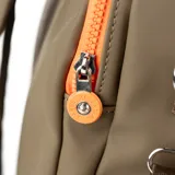 Bolso matero verde de poliéster con doble cierre, asas fijas y correa regulable. Tiene dos bolsillos externos con cierre, un bolsillo interno con cierre y dos bolsillos internos abiertos. El interior es de tela de algodón y poliéster. Tiene compartimentos para notebook y matero, y el logo de la marca en el frente.