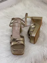 Sandalias de fiesta color champagne con plataforma y taco cuadrado, tiras cruzadas en el empeine y pulsera al tobillo con hebilla.