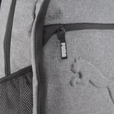 Mochila Puma unisex color gris con detalles en negro. Tiene un compartimento principal con cierre, un bolsillo frontal con cierre y un bolsillo lateral de malla. El logo de Puma está estampado en relieve en el frente.
