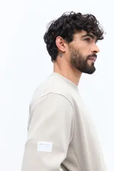 Buzo de algodón color beige claro, con cuello redondo y puños. Presenta un estampado grande en la espalda con texto en gris y blanco, incluyendo referencias a 'London', 'Southbank Art Gallery Centre' y una representación estilizada de la bandera del Reino Unido.