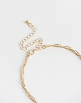Collar corto dorado con cadena de eslabones y cadena de cuentas de colores. Incluye dije de moneda dorada con estrella grabada y dije de corazón de piedra azul.