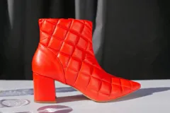 Bota corta de cuero rojo con diseño capitoneado, forro y plantilla de cuero. Taco cuadrado de 6 cm.
