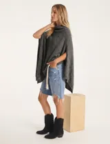 Poncho tejido de punto grueso, color mostaza/mostaza oscuro, con cuello redondo y caída amplia.