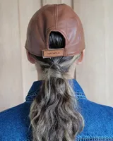 Gorro tipo visera de cuero, con ajuste trasero, diseño minimalista.