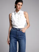 Camisa sin mangas blanca con aplique de brillo y botones en el frente.