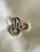 Aros pequeños con dije circular de resina azul con glitter y borde de strass plateado, con gancho de acero quirúrgico.