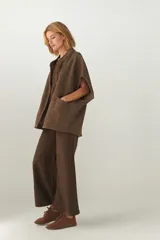 Chaleco color crema de lana sin teñir, corte recto, con cuello y solapa pronunciadas, broches a presión y bolsillos ojal.