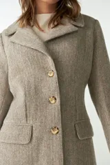 Tapado marrón de lana con cuello con solapa, manga larga, forrado, con bolsillos y cierre frontal con botones.