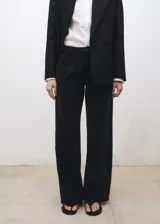 Pantalón de jean negro de corte wide leg, tiro medio y pinzas delanteras.