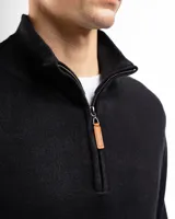 Sweater verde de punto con cuello alto y cierre medio con cremallera.