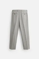 Pantalón de vestir gris claro con textura, corte regular fit, bolsillos laterales y traseros de doble vivo con botón. Cierre frontal con cremallera y botón.