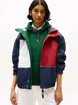 Campera náutica amplia reversible de nailon, con diseño color block en rojo, blanco y azul marino. Tiene capucha fija, cierre de cremallera oculto con botones a presión, puños y bajo elásticos, dos bolsillos ribeteados en la cintura, parche con logo de Tommy Hilfiger en el pecho y logo de Tommy Hilfiger en el cuello, las mangas y la espalda.