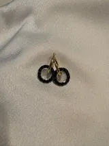Aros con diseño de doble aro, decorados con piedras multicolores y disponibles en acabado dorado o plateado.