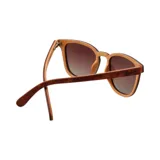 Lentes de sol con montura cuadrada color marrón con efecto madera y lentes degradadas color marrón.