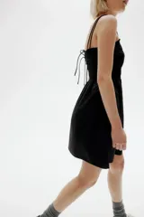 Vestido corto negro de algodón con cuerpo fruncido, escote cuadrado y breteles spaghetti dobles.