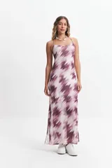 Vestido largo con estampado difuminado en tonos borgoña y blanco, breteles finos regulables y espalda con tiras entrecruzadas. Tiene escote en “V” y tajos laterales.