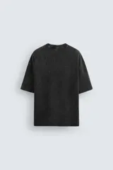 Camiseta azul marino de corte holgado, confeccionada en algodón con cuello redondo y mangas cortas. Presenta un efecto de lavado que le da una apariencia única.