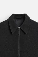 Sobrecamisa de tweed multicolor con cuello solapa, cierre frontal con cremallera, bolsillos laterales y puños abotonados.