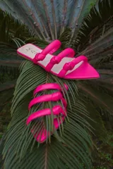Sandalias de cuero color fucsia con tres tiras gruesas sobre el empeine, cada una con un nudo decorativo.