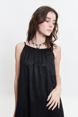 Vestido largo de poliéster con estampado geométrico en tonos borgoña, beige y blanco. Tiene breteles finos y escote redondeado con frunces sutiles en la parte delantera y trasera.