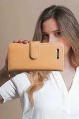 Billetera larga color camel con presilla y broche a presión. Interior con visor, tarjeteros y bolsillos. Compartimento posterior con cierre metálico, incluye bolsillos y monedero con cierre.