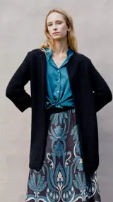 Chaqueta de punto color negro, de corte recto y largo midi.