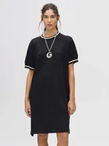 Vestido corto negro de tejido calado, con cuello redondo y mangas cortas con ribete en contraste.