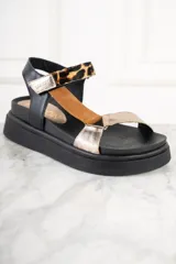 Sandalias de cuero con plataforma, color negro, con tiras de cuero color suela y dorado. Tira trasera de cuero negro con hebilla y tira delantera con estampado animal print.