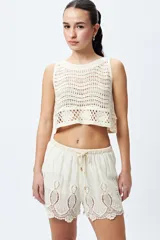 Short color crudo con detalle de bordado calado en el ruedo y cintura con cordón ajustable.