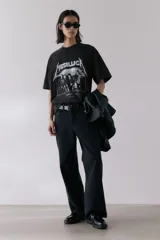 Remera negra de algodón con estampado del logo de Metallica y la imagen de la banda Damage Inc. 1986. Corte oversized con cuello redondo ribeteado, hombros caídos y bajo recto.