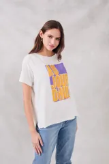 Remera blanca de corte holgado con estampado frontal de un recuadro violeta con la frase "Au jour d'hui!" en letras color naranja.