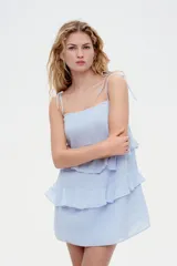 Vestido corto celeste con tirantes finos y volantes en capas.