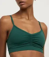 Top deportivo negro de microfibra, con breteles finos y detalle fruncido en el busto.