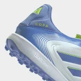 Championes de fútbol Adidas Copa Pure 3 League para pasto sintético, color plateado metálico con detalles en azul lavanda y cordones en el mismo tono. Presentan las tres franjas de Adidas en azul con un borde de costura zigzag en color verde lima.