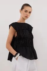 Blusa negra con escote redondo, sin mangas y detalle de frunces horizontales en el frente.