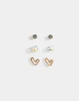 Set de tres pares de aros pasantes dorados: un par con strass, un par con forma de cubo y un par con forma de corazón.