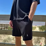 Short de tejido color blanco con logo bordado en negro en la pierna izquierda.