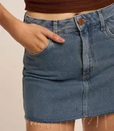 Minifalda de jean azul con bolsillos delanteros y traseros, cierre con botón y cremallera.