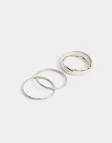 Set de tres pulseras rígidas doradas de metal, de diferentes tamaños.